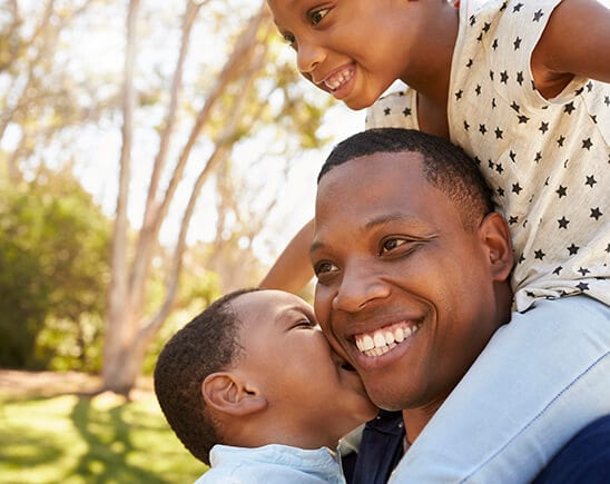 A Father Smiling With his Children